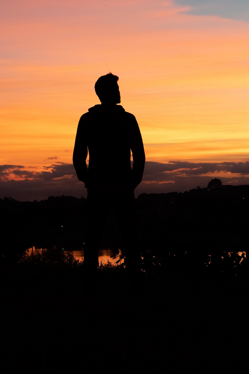 Homme regardant à l'horizon par un couché de soleil